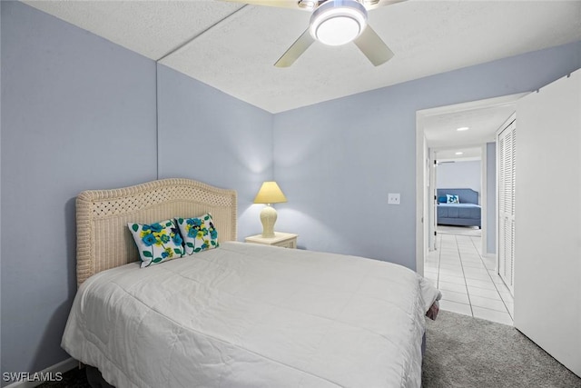 carpeted bedroom featuring tile patterned floors and ceiling fan