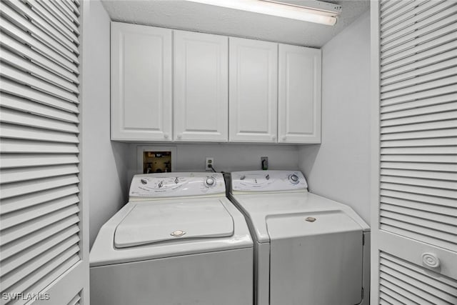 washroom with cabinet space and washing machine and dryer