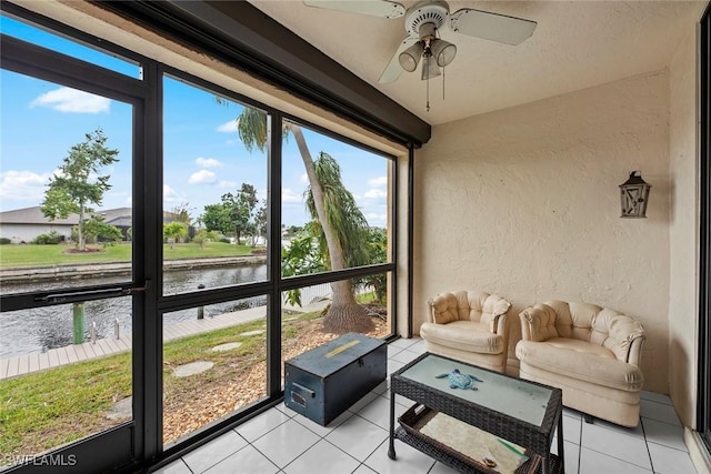 sunroom / solarium featuring a water view and ceiling fan