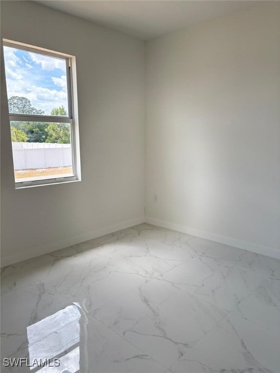 4118 4th St SW, Lehigh Acres, FL 33976 - empty room featuring baseboards and marble look tile flooring