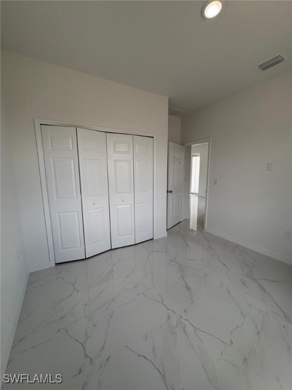 4118 4th St SW, Lehigh Acres, FL 33976 - unfurnished bedroom featuring baseboards, a closet, and marble finish floors