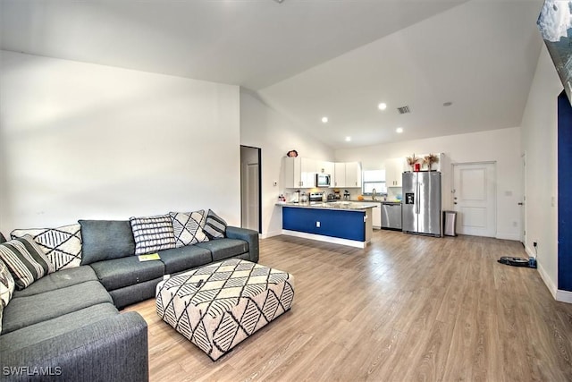 5007 W Hummingbird Dr, Labelle, FL 33935 - living area with lofted ceiling, light wood-style floors, and baseboards