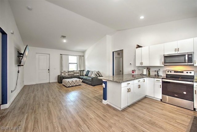 5007 W Hummingbird Dr, Labelle, FL 33935 - kitchen with appliances with stainless steel finishes, lofted ceiling, a peninsula, white cabinetry, and light wood-style floors
