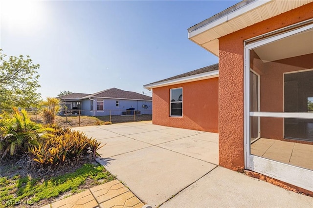 209 Magellan St, Fort Myers, FL 33913 - view of side of property with stucco siding, a patio area, and fence