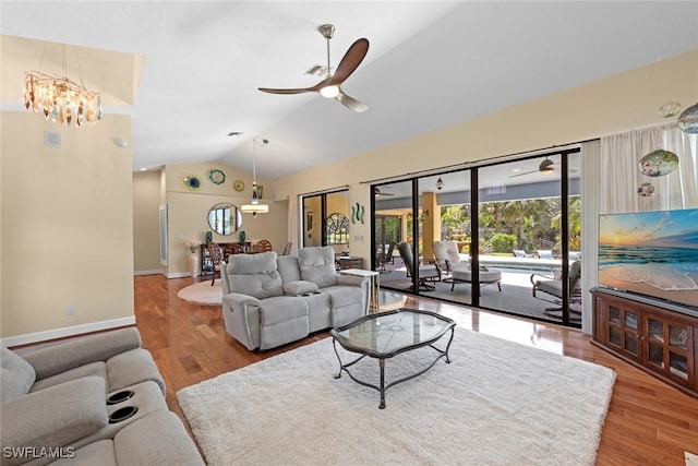 living room with vaulted ceiling, wood finished floors, a chandelier, a ceiling fan, and baseboards