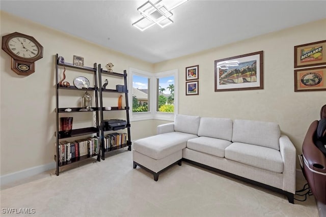 living area with light colored carpet and baseboards