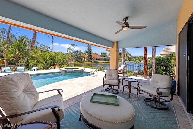 view of swimming pool featuring a patio area, a water view, fence, ceiling fan, and a pool with connected hot tub