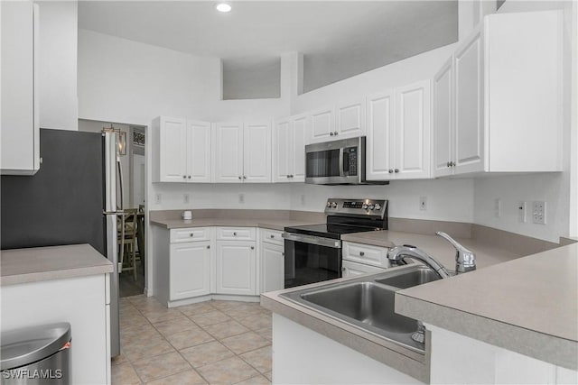 170 Vista Ln, Naples, FL 34119 - kitchen with stainless steel appliances, a sink, white cabinetry, light tile patterned floors, and recessed lighting