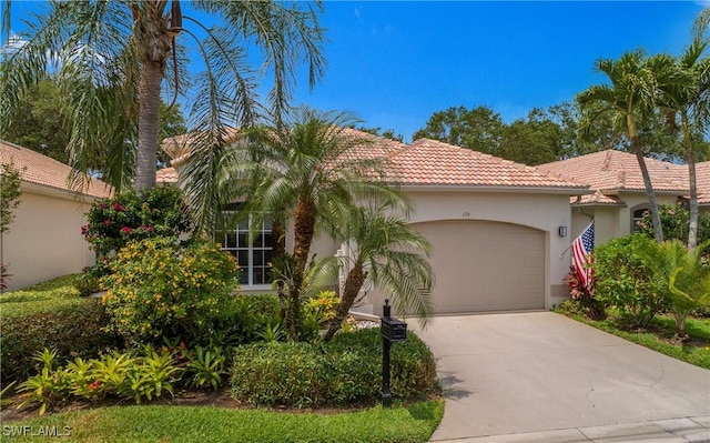 170 Vista Ln, Naples, FL 34119 - mediterranean / spanish house featuring a garage, concrete driveway, a tile roof, and stucco siding