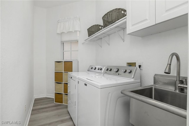 170 Vista Ln, Naples, FL 34119 - laundry area featuring cabinet space, separate washer and dryer, light wood-style flooring, and baseboards