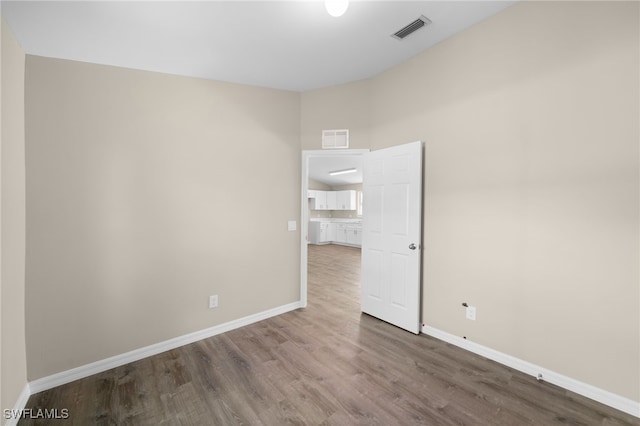 empty room featuring wood finished floors and baseboards
