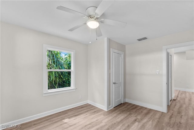 unfurnished bedroom featuring light wood-style floors, baseboards, a ceiling fan, and a closet