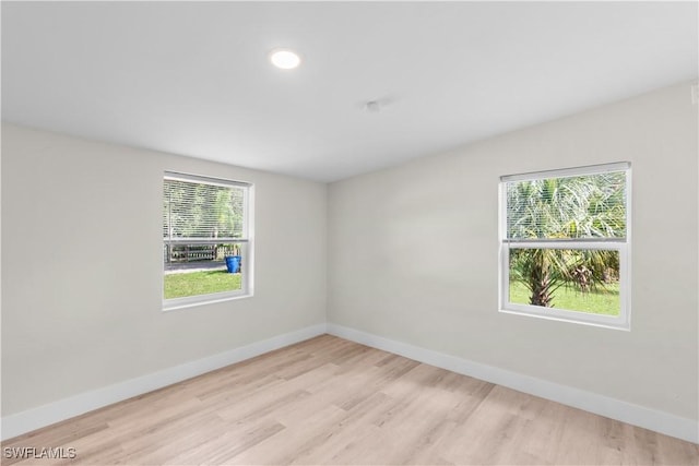 empty room with baseboards and light wood-style flooring
