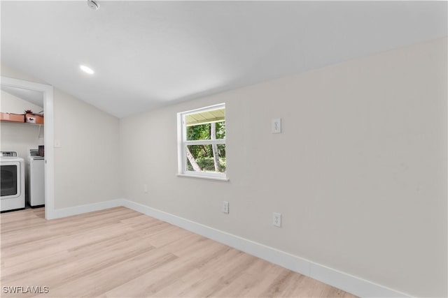 empty room featuring washer and dryer, lofted ceiling, baseboards, and light wood-style flooring