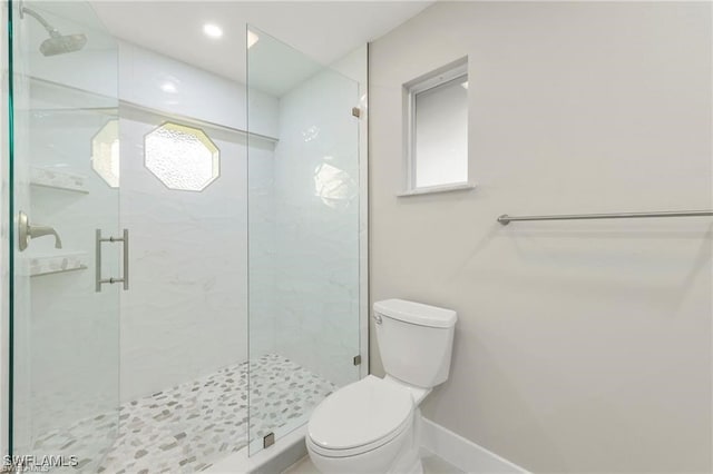 full bath with toilet, a marble finish shower, and baseboards