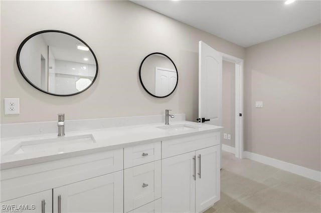 bathroom with double vanity, baseboards, and recessed lighting