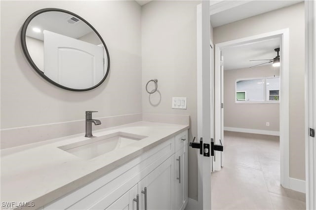 bathroom with a ceiling fan, vanity, and baseboards