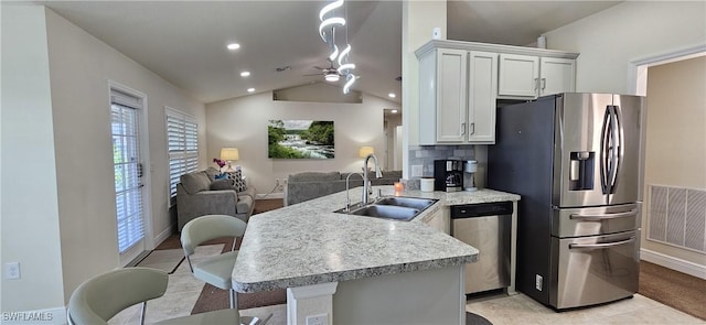 1948 Redmont Ave, Lehigh Acres, FL 33972 - kitchen with appliances with stainless steel finishes, a peninsula, open floor plan, lofted ceiling, and light countertops