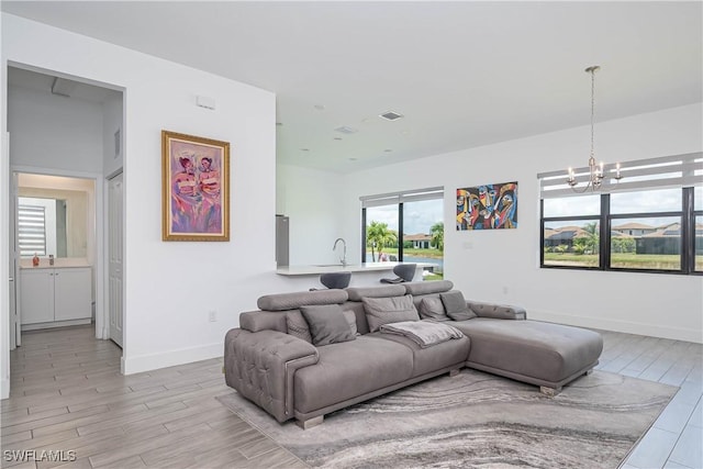 5461 Soria Ave, Ave Maria, FL 34142 - living room with a chandelier, light wood-style flooring, and baseboards