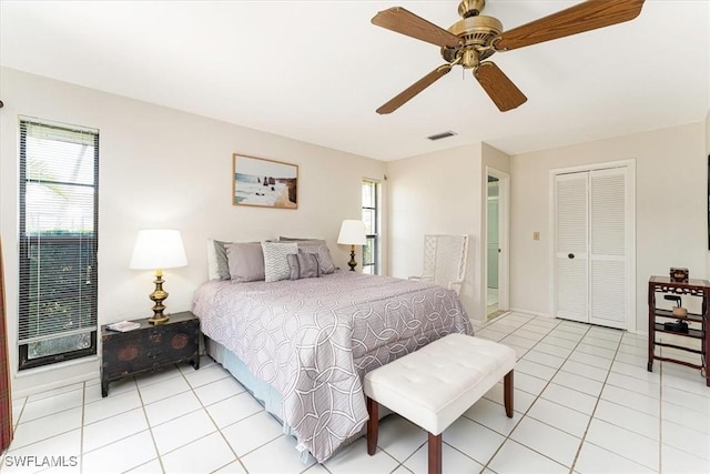 bedroom featuring multiple windows, light tile patterned floors, and a closet