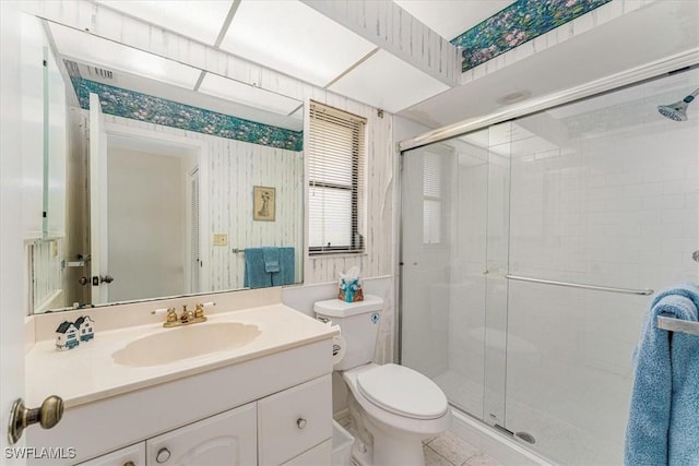 bathroom with a stall shower, toilet, and vanity