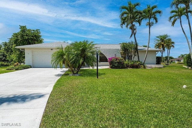 view of front of property with concrete driveway, a garage, a front yard, and stucco siding