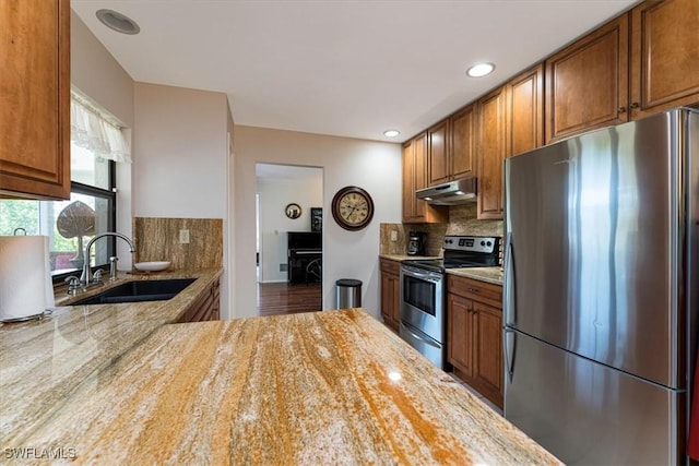 116 Short Ct, Naples, FL 34112 - kitchen with stainless steel appliances, under cabinet range hood, decorative backsplash, light stone countertops, and recessed lighting