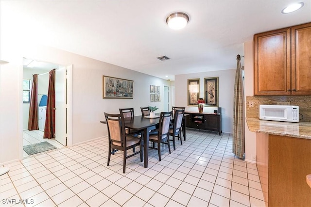 dining room featuring light tile patterned floors and baseboards
