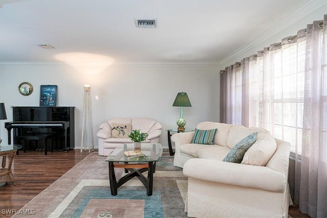 living area with healthy amount of natural light, ornamental molding, wood finished floors, and baseboards