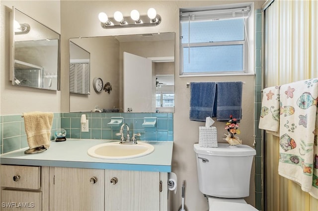 full bath featuring backsplash, toilet, vanity, and a shower