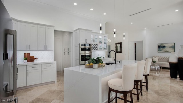 3936 Deep Passage Way, Naples, FL 34109 - kitchen featuring a sink, double oven, refrigerator, a breakfast bar, and tasteful backsplash