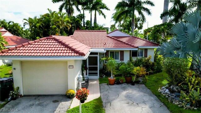 7232 Saint Anns Ct, Fort Myers, FL 33908 - view of front of home with stucco siding, a tiled roof, a garage, and driveway