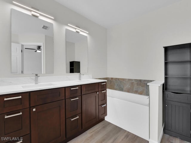 3521 SE Santa Barbara Pl, Cape Coral, FL 33914 - full bathroom with wood finished floors, a bath, double vanity, and ceiling fan