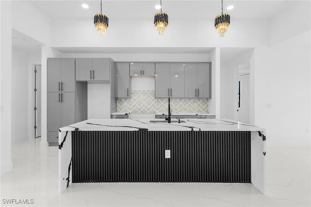 634 Raintree St E, Lehigh Acres, FL 33974 - kitchen with gray cabinetry, light marble finish flooring, backsplash, hanging light fixtures, and recessed lighting