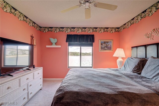 9950 Sailview Ct Unit 14, Fort Myers, FL 33905 - bedroom featuring light carpet, a textured ceiling, a water view, and ceiling fan