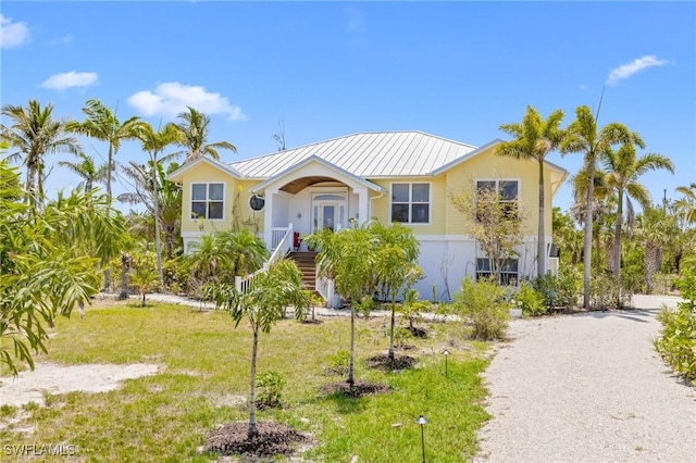 3008 Turtle Gait Ln, Sanibel, FL 33957 - view of front of home with metal roof, a standing seam roof, and a front lawn