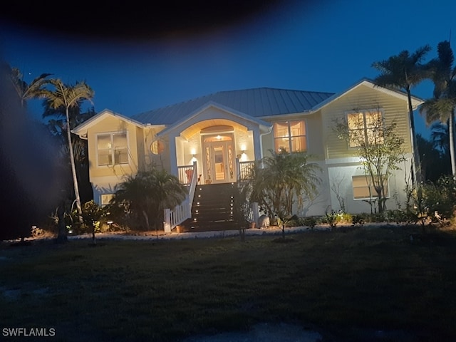 3008 Turtle Gait Ln, Sanibel, FL 33957 - view of front facade featuring metal roof, a porch, a yard, stairway, and a standing seam roof