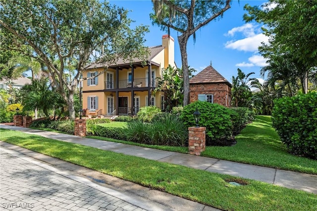 1419 Hemingway Pl, Naples, FL 34103 - view of front facade with a balcony, a front yard, a chimney, and stucco siding