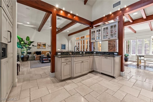 1419 Hemingway Pl, Naples, FL 34103 - kitchen with a sink, beamed ceiling, stone tile floors, open floor plan, and glass insert cabinets