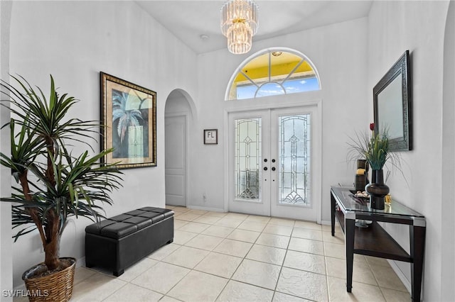 2005 SE 21st St, Cape Coral, FL 33990 - entrance foyer featuring arched walkways, french doors, a chandelier, a high ceiling, and light tile patterned floors