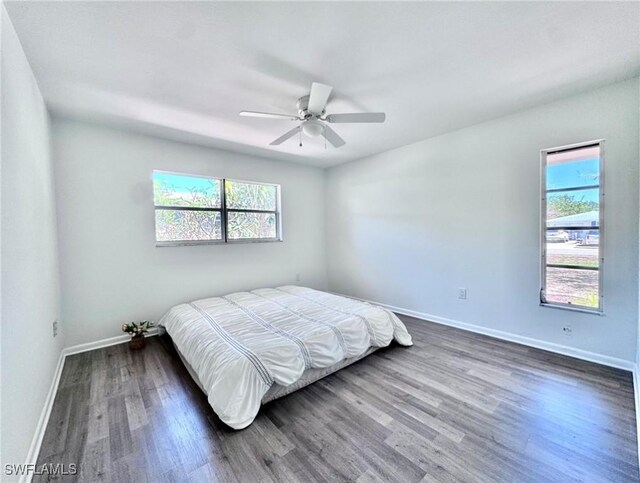 844 106th Ave N, Naples, FL 34108 - bedroom with multiple windows, baseboards, wood finished floors, and ceiling fan