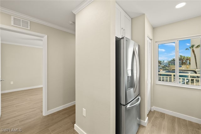 7400 Estero Blvd Unit 125, Fort Myers Beach, FL 33931 - kitchen featuring stainless steel fridge with ice dispenser, baseboards, light wood-style flooring, white cabinets, and ornamental molding