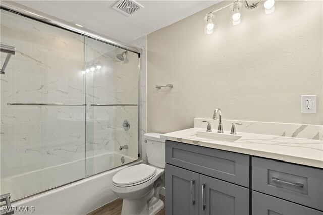 7400 Estero Blvd Unit 125, Fort Myers Beach, FL 33931 - full bath featuring vanity, toilet, combined bath / shower with glass door, and wood finished floors