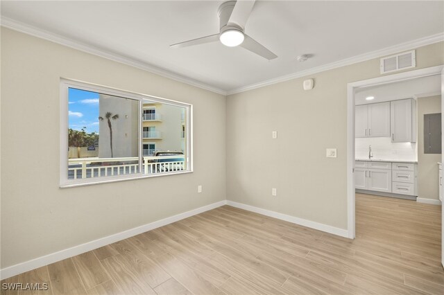 7400 Estero Blvd Unit 125, Fort Myers Beach, FL 33931 - unfurnished room featuring ornamental molding, a sink, a ceiling fan, baseboards, and light wood finished floors