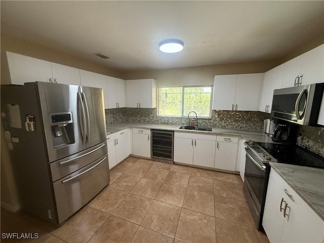 4335 18th Ave SE, Naples, FL 34117 - kitchen with stainless steel appliances, wine cooler, a sink, tasteful backsplash, and light tile patterned floors