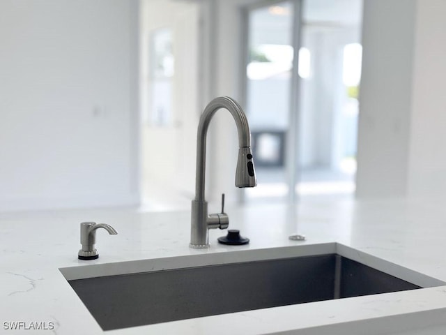 kitchen view of a sink and light stone countertops