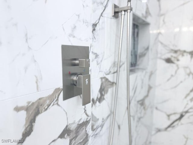 bathroom view of a marble finish shower
