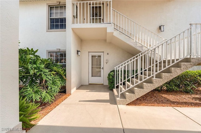 doorway to property featuring stucco siding