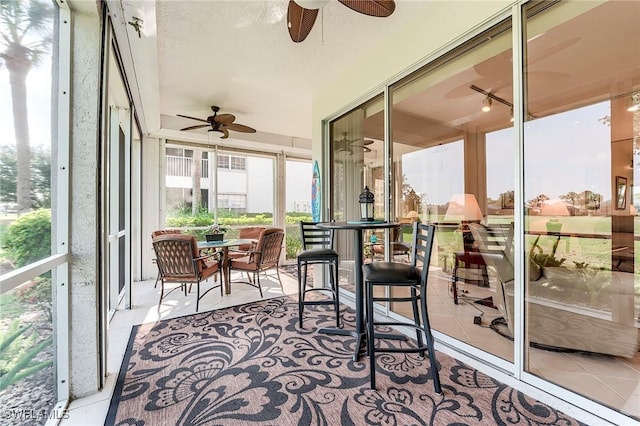 sunroom / solarium featuring a ceiling fan and outdoor dining area