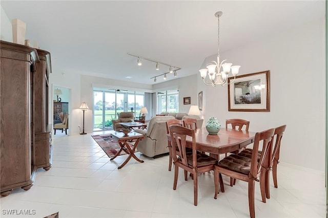 dining space with track lighting, a chandelier, and light tile patterned floors